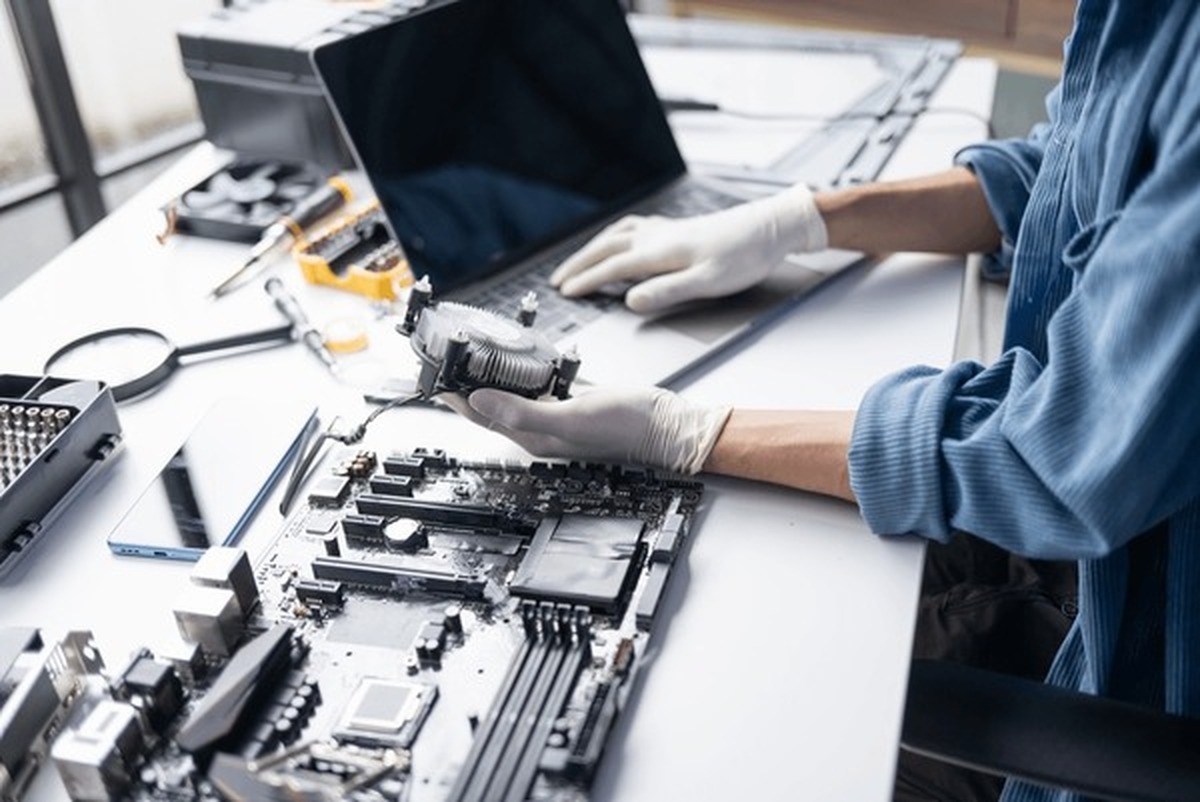 Teknik servis merkezinde anakart ve soğutucu üzerinde çalışan teknisyen